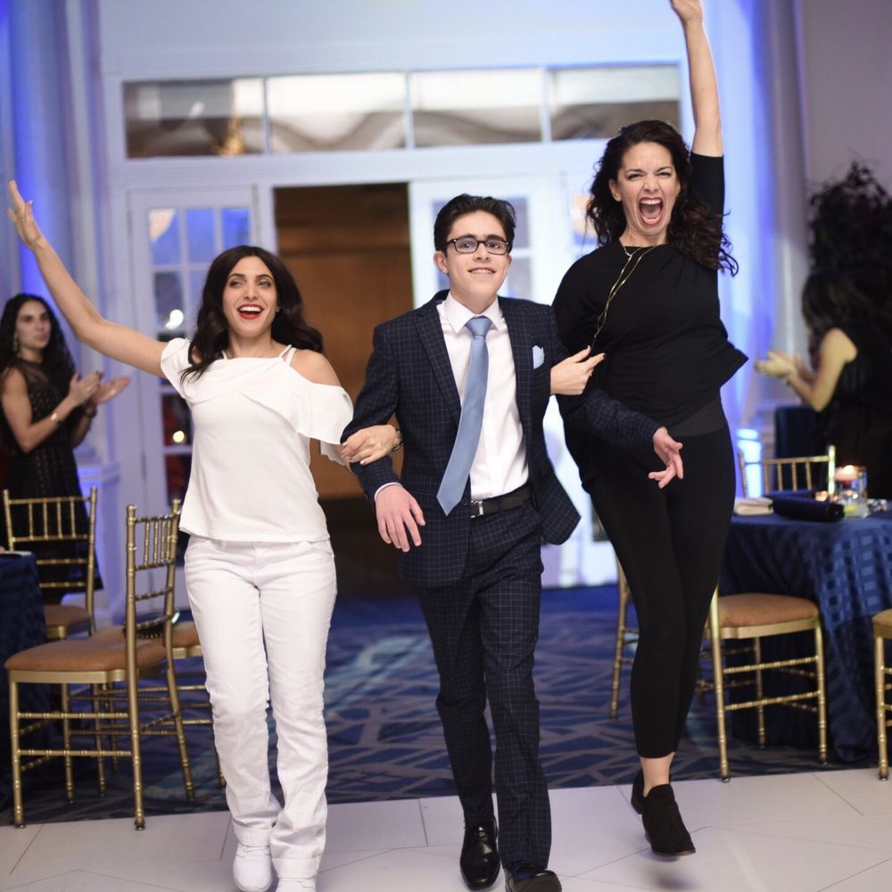 Bar Mitzvah boy making his grand entrance with two dancers