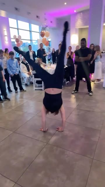 Dancer doing a handstand on the dance floor while guests watch